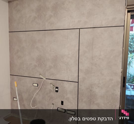 קיר עם טפט אפור, חוטים וכלי עבודה